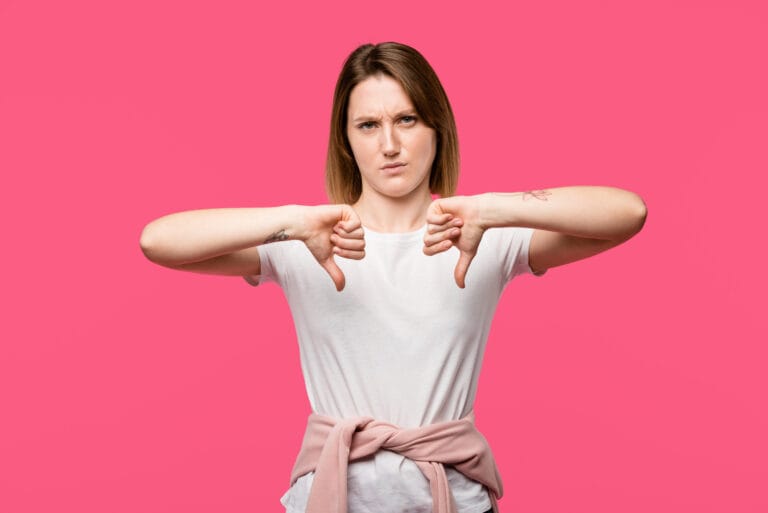 Emotional stylish girl showing thumbs down gesture