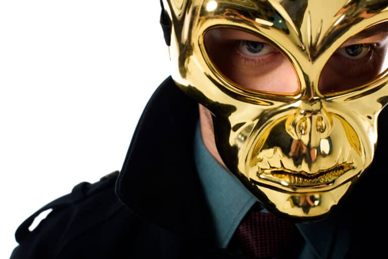 Portrait of criminal in golden mask and black coat