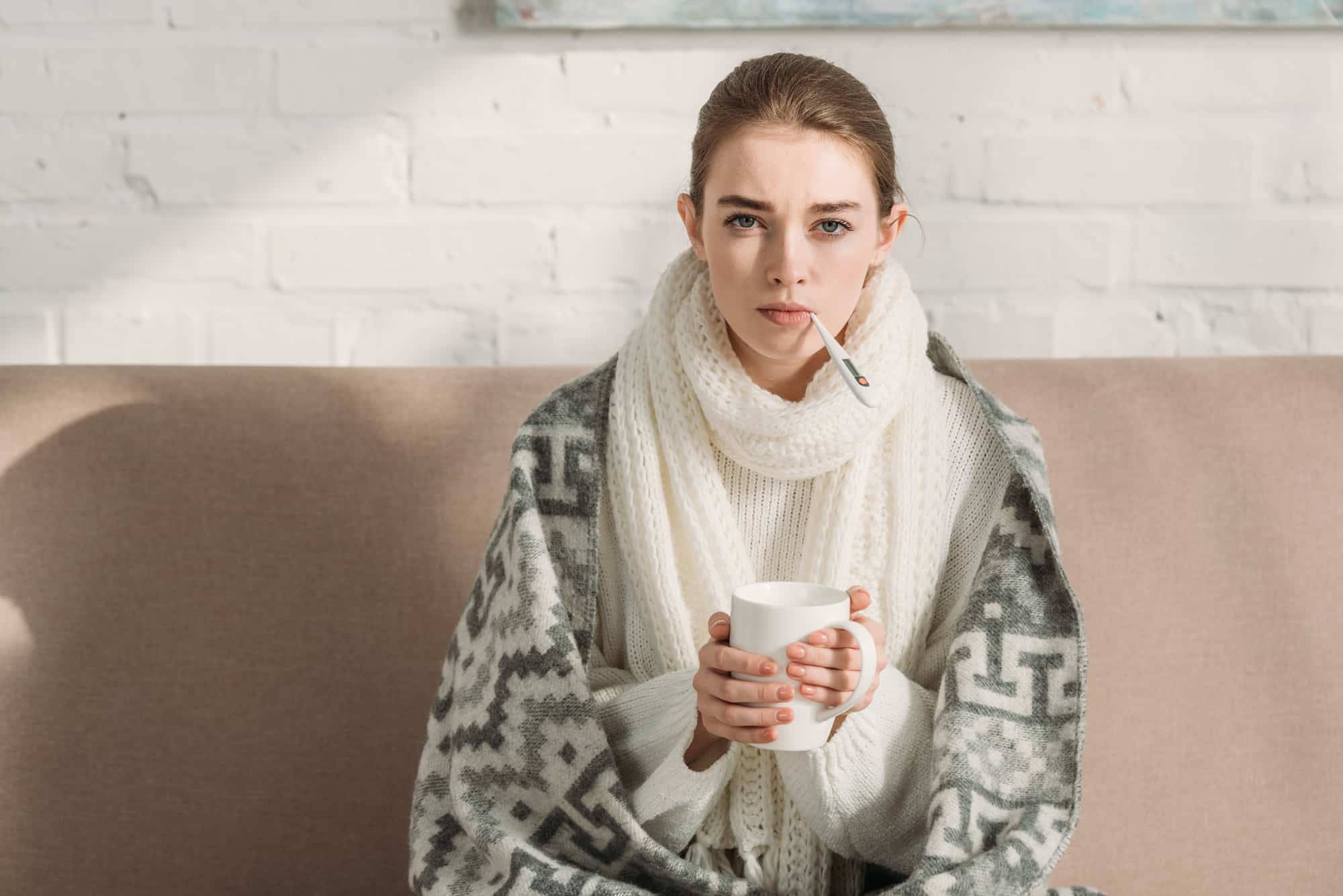 Sick girl looking at camera while measuring temperature