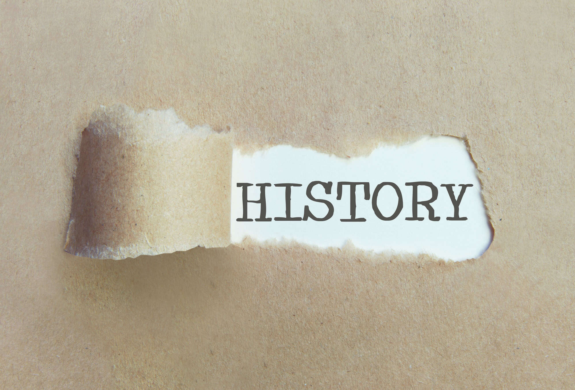 Torn brown paper revealing the word history