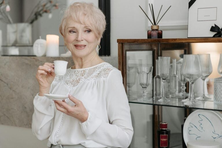 Elderly Woman Holding a White Cup while Looking Away