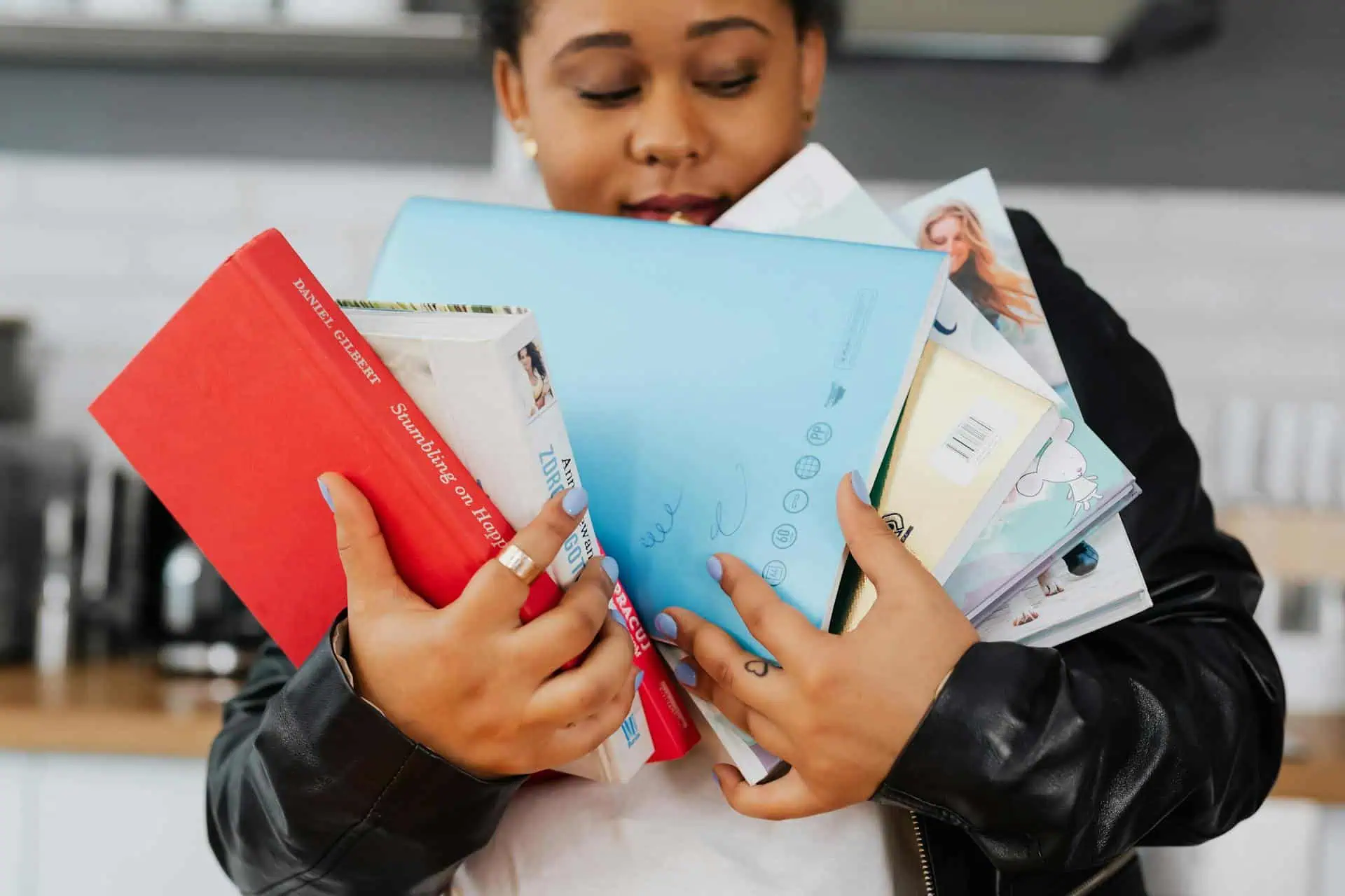 Woman in Black Leather Jacket Holding Six Books