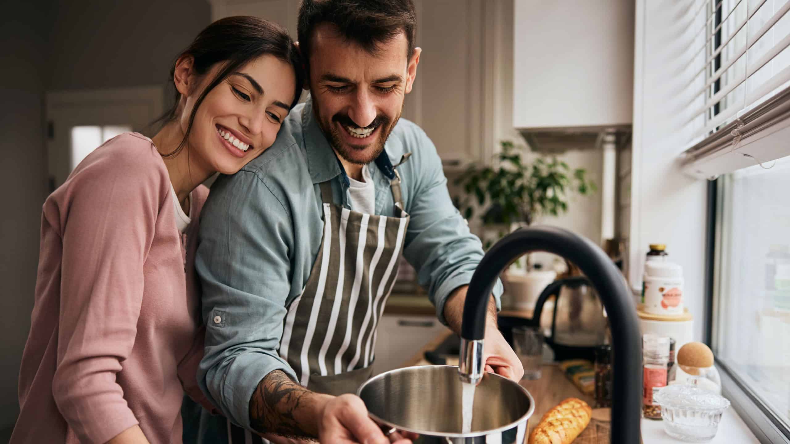 Happy couple having fun while preparing a meal in the kitchen.