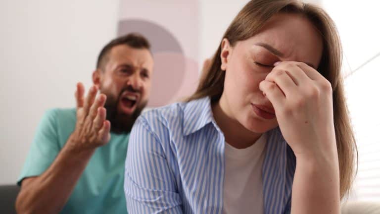 Betrayal. Angry man shouting at his frustrated wife at home, selective focus