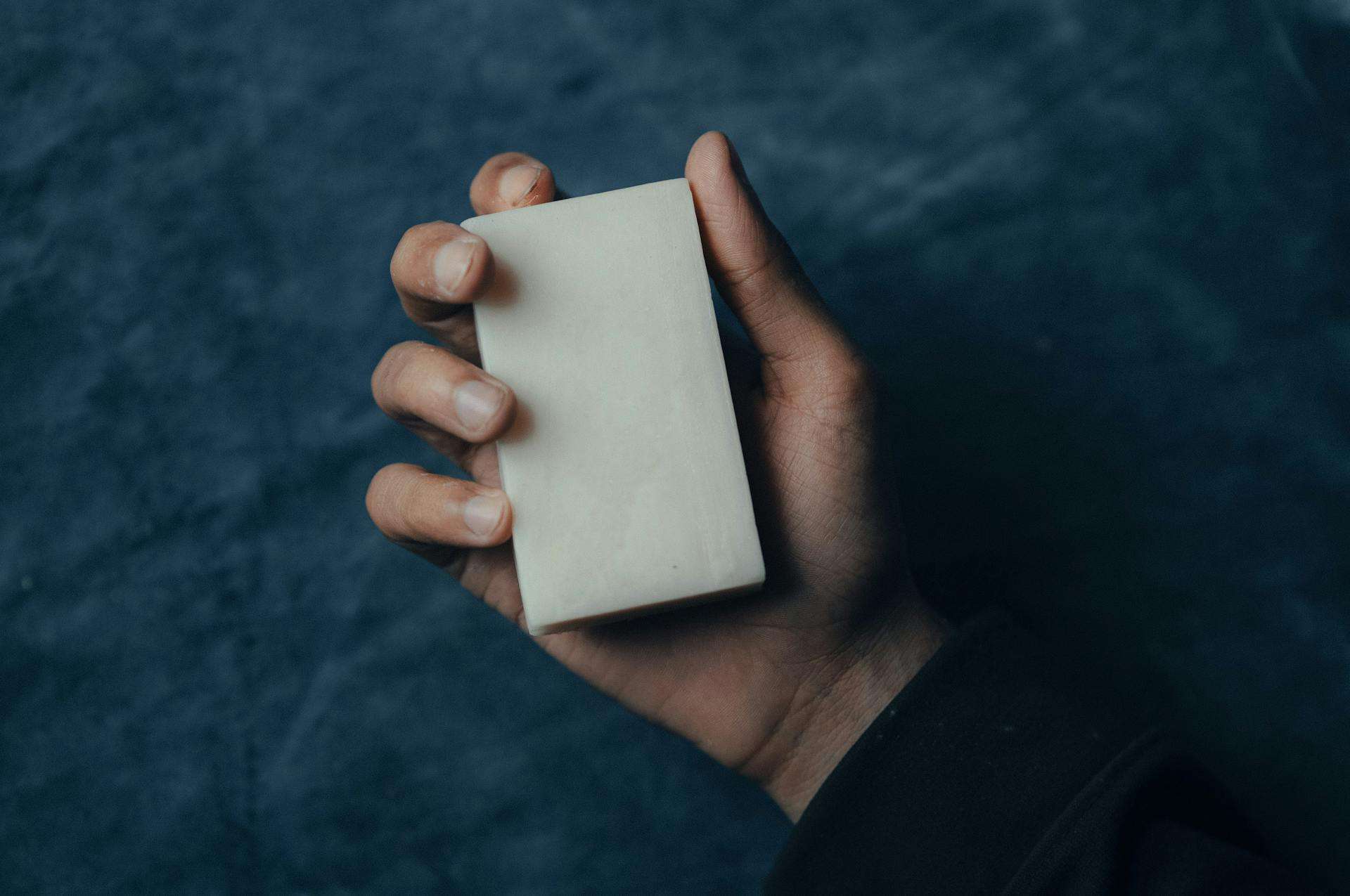 Person Holding a Bar of Soap