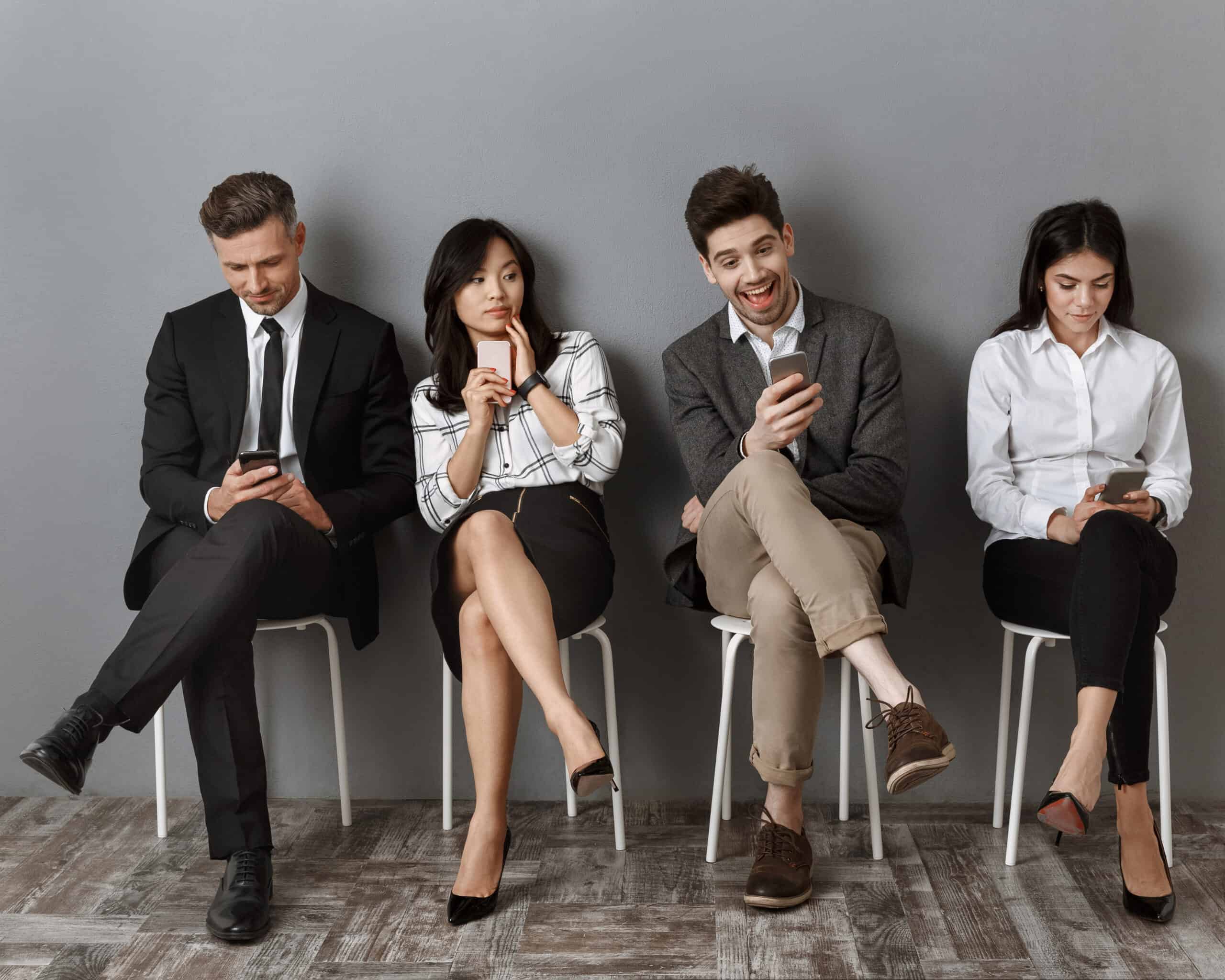 Business people in formal wear with smartphones waiting for job interview