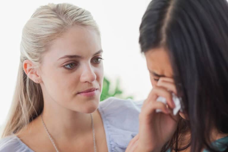 Blonde listening to her tearful friend