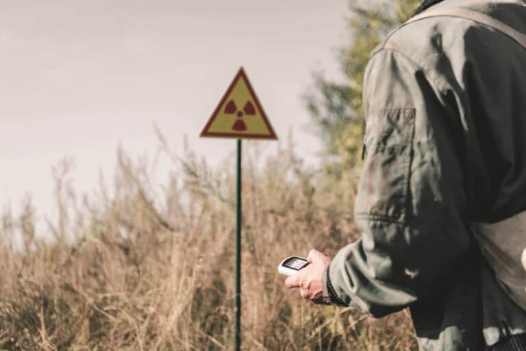 Cropped view of man holding radiometer near toxic symbol