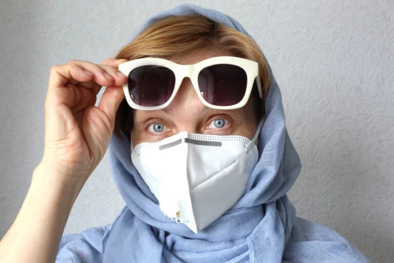 Stylish mature woman wearing filter face mask against virus.