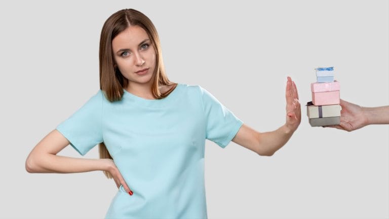 Birthday disappointment. Bad gift. Arrogant woman in blue rejecting presents isolated on neutral empty space background. Relationship breakup.