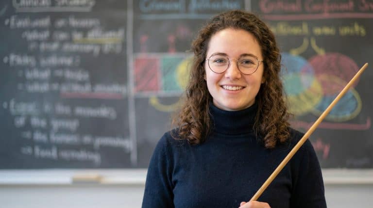 young teacher close-up with glasses and a pointy stick
