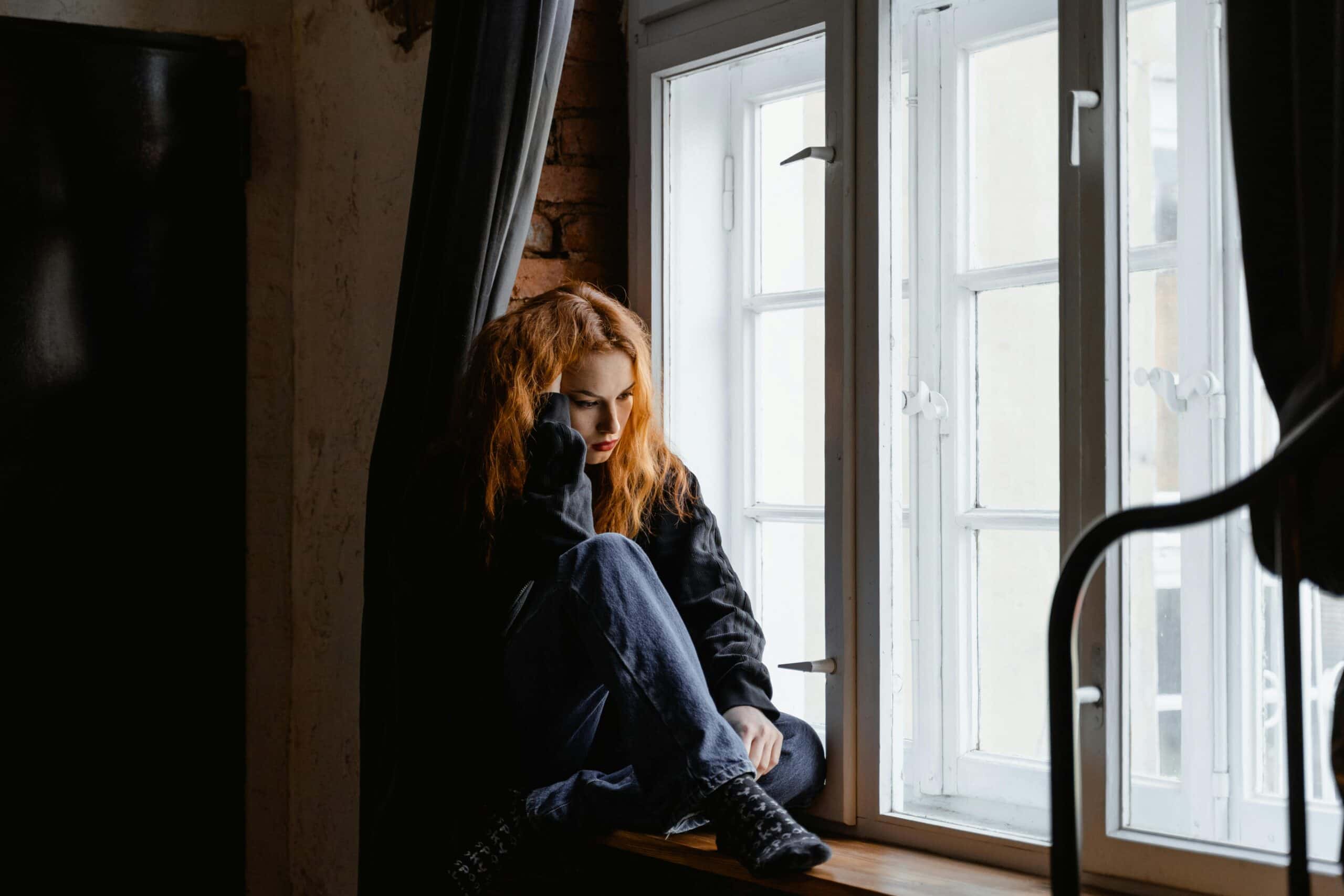 Sad Woman in Black Leather Jacket Sitting on Brown Wooden Floor