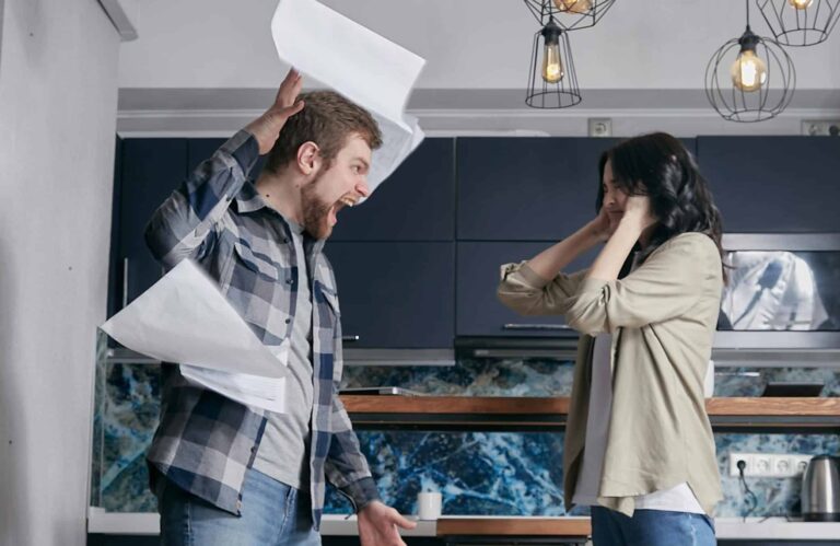 Couple arguing while man throws paper in the air