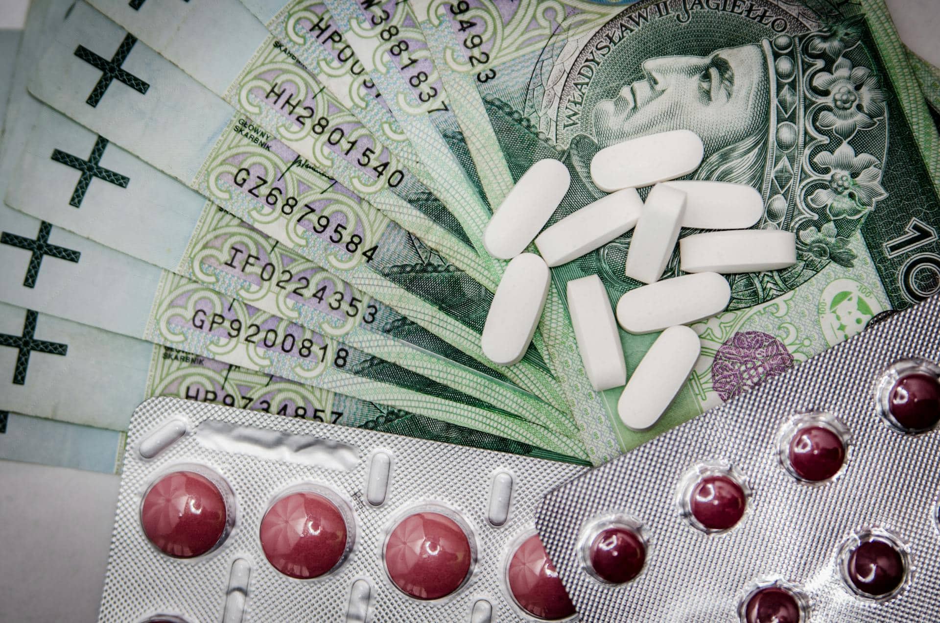 White Oval Medication Pill Beside Blister Pack and Money