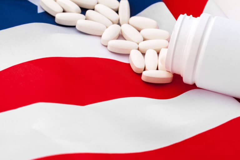 White prescription pills on United States flag. Close up.