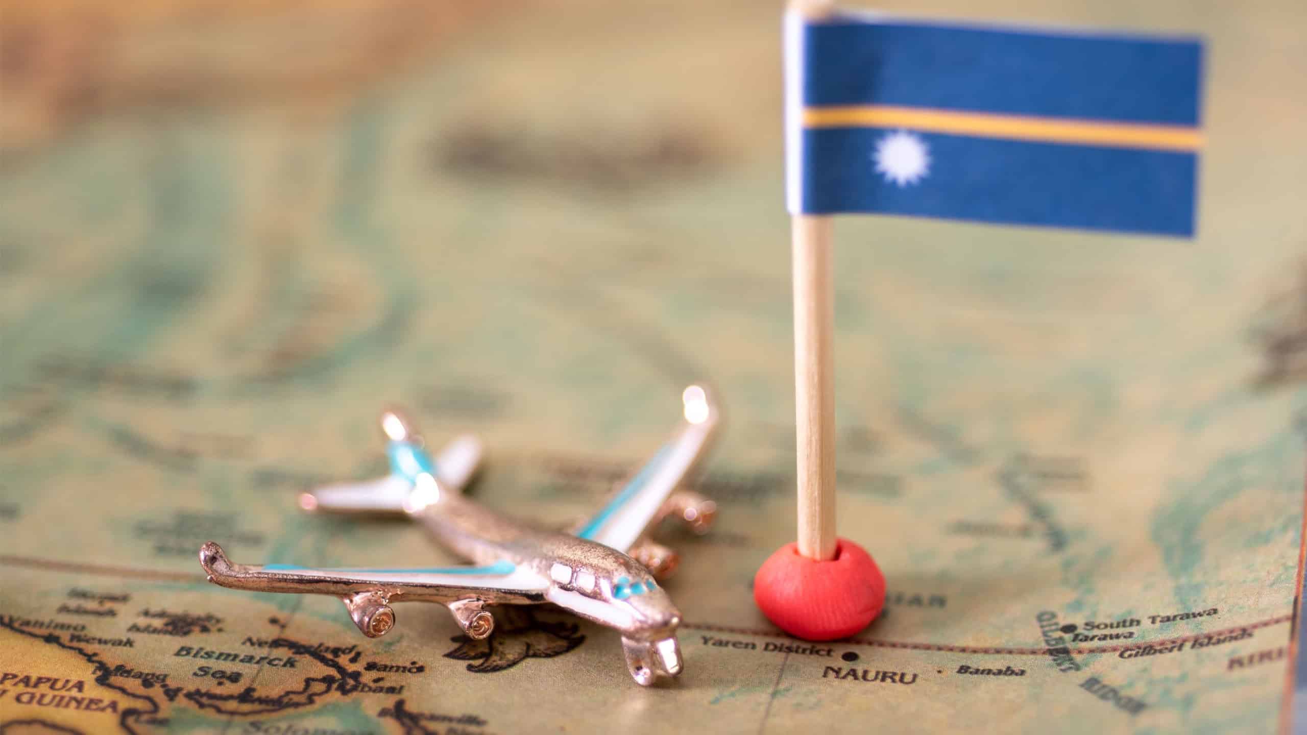 the flag of Nauru and the plane on the world map. The concept of travel and recreation in Nauru