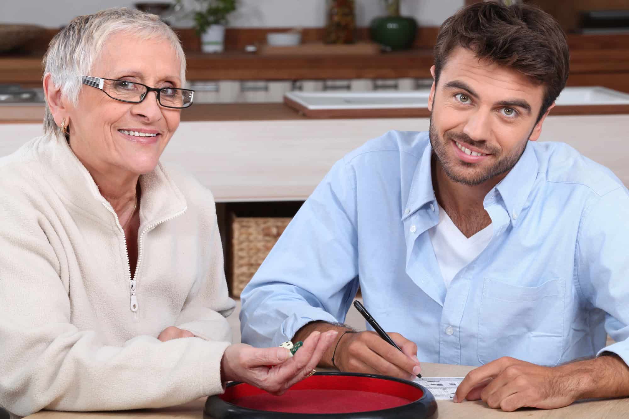 Young man playing dice with older woman