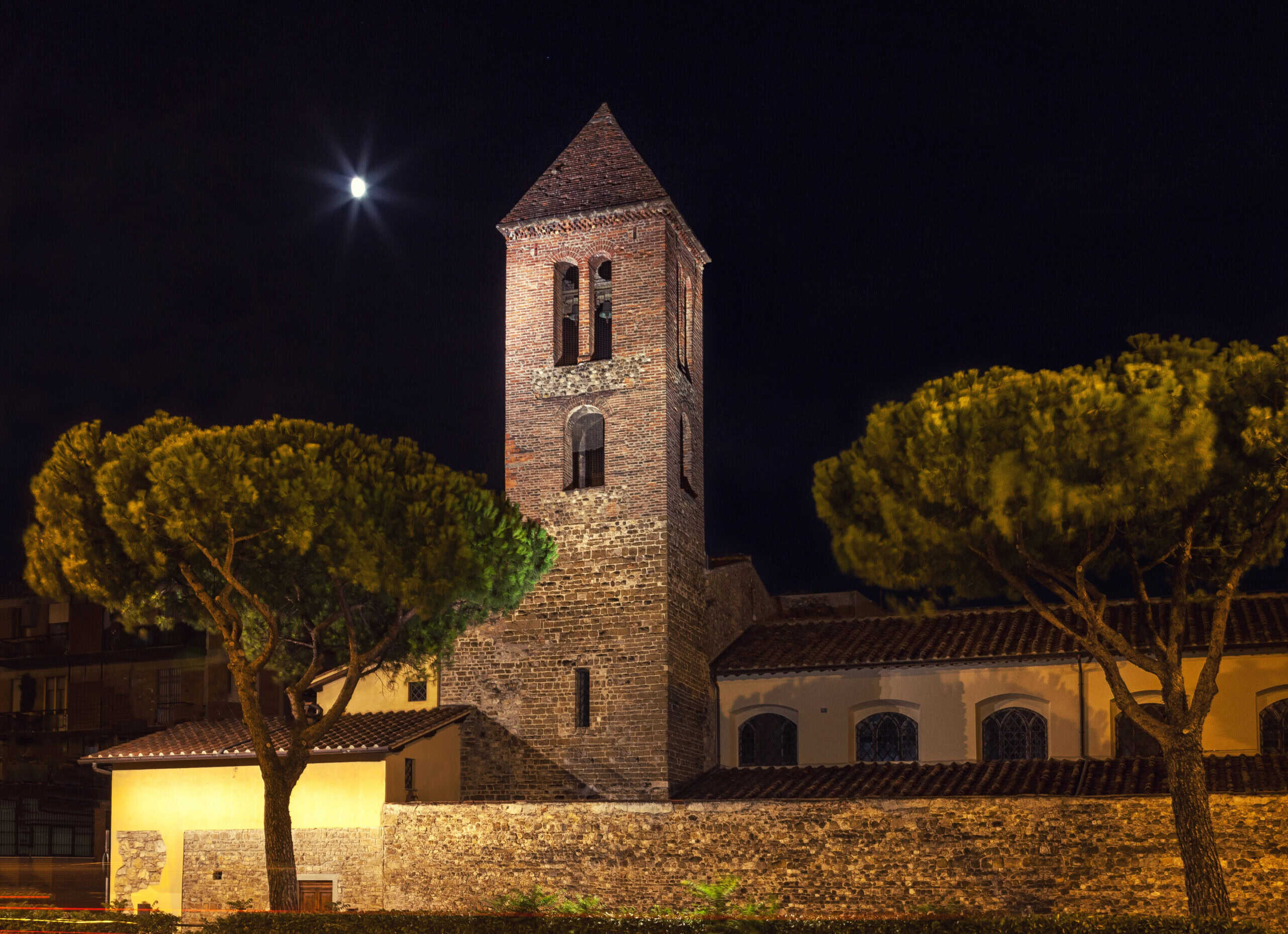 Stone fortress with a bell tower at night. Ancient old architecture in the moonlight, Florence Italy