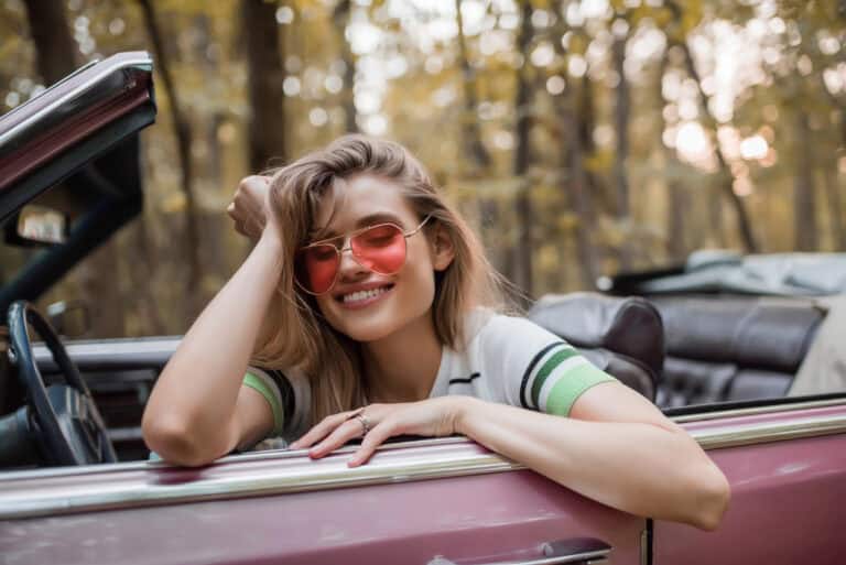 Happy woman in sunglasses holding hand near head