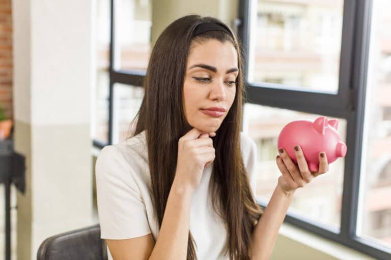 pretty young woman with a piggy bank. savings concept. house interior design