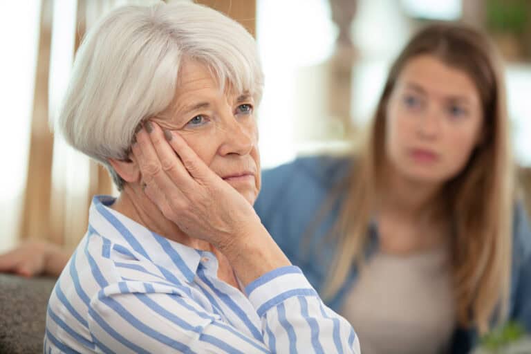 daughter comforting upset older woman having problems