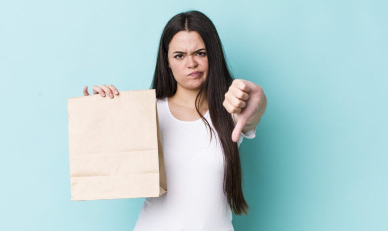 young adult woman feeling cross,showing thumbs down. take away concept