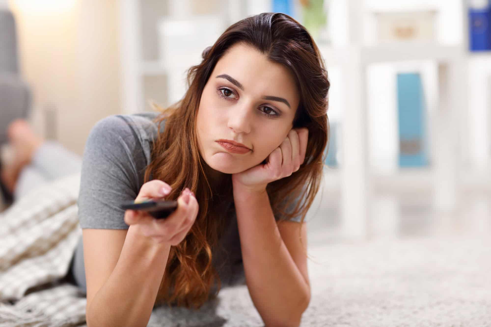 Picture of beautiful young woman relaxing at home watching tv