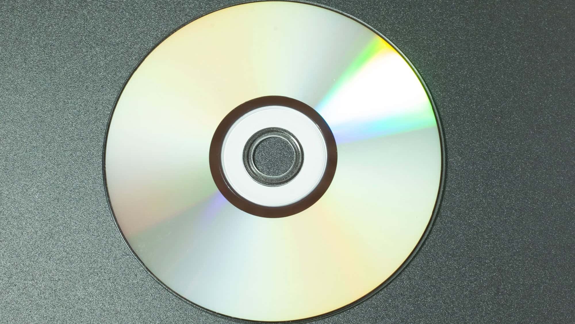 Compact Disc CD with drivers for the computer, shiny on a dark background
