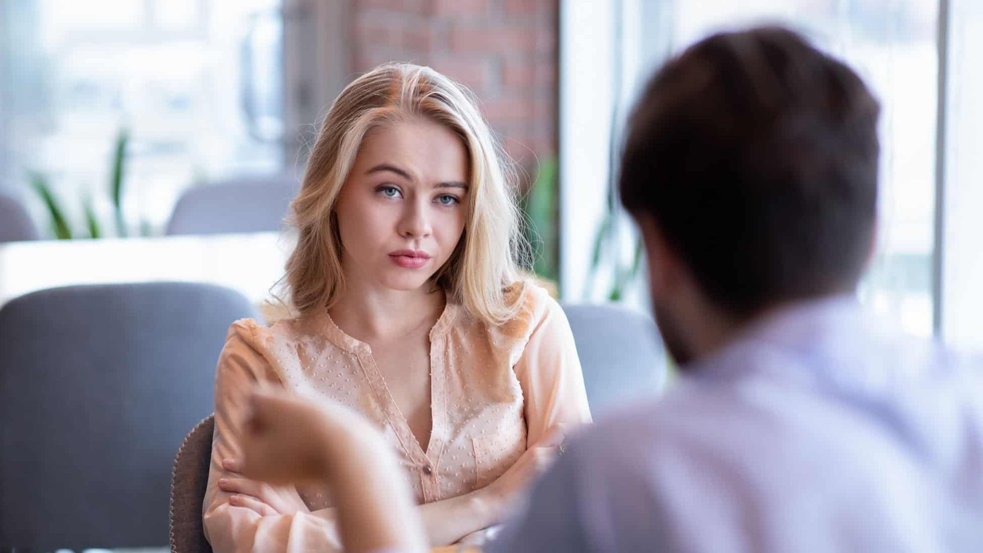 Bad date. Young woman feeling bored during dinner at cafe, unhappy with her boyfriend, disinterested in conversation. Stressed couple having difficulties in relationship, arguing in coffee shop