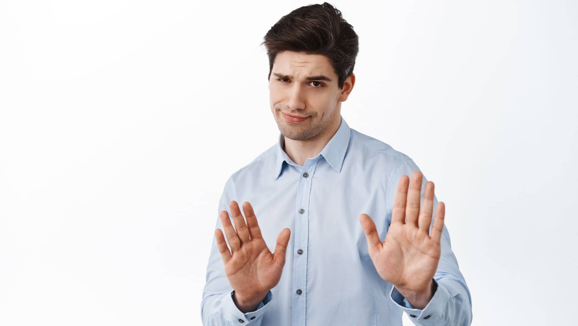 Slow down, stop, stay away, keep social distance. Skeptical boss, male entrepreneur showing refuse, reject block gesture, telling to quit, standing over white background