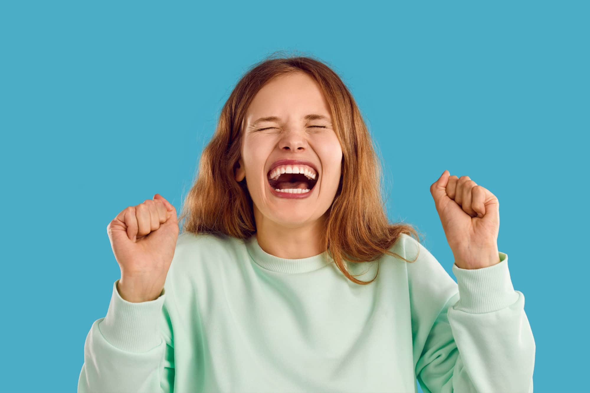 Happy young woman with beautiful genuine candid perfect toothy smile laughing with mouth wide open at funny joke. Head shot angry naughty capricious unruly teenage girl throwing tantrum and
