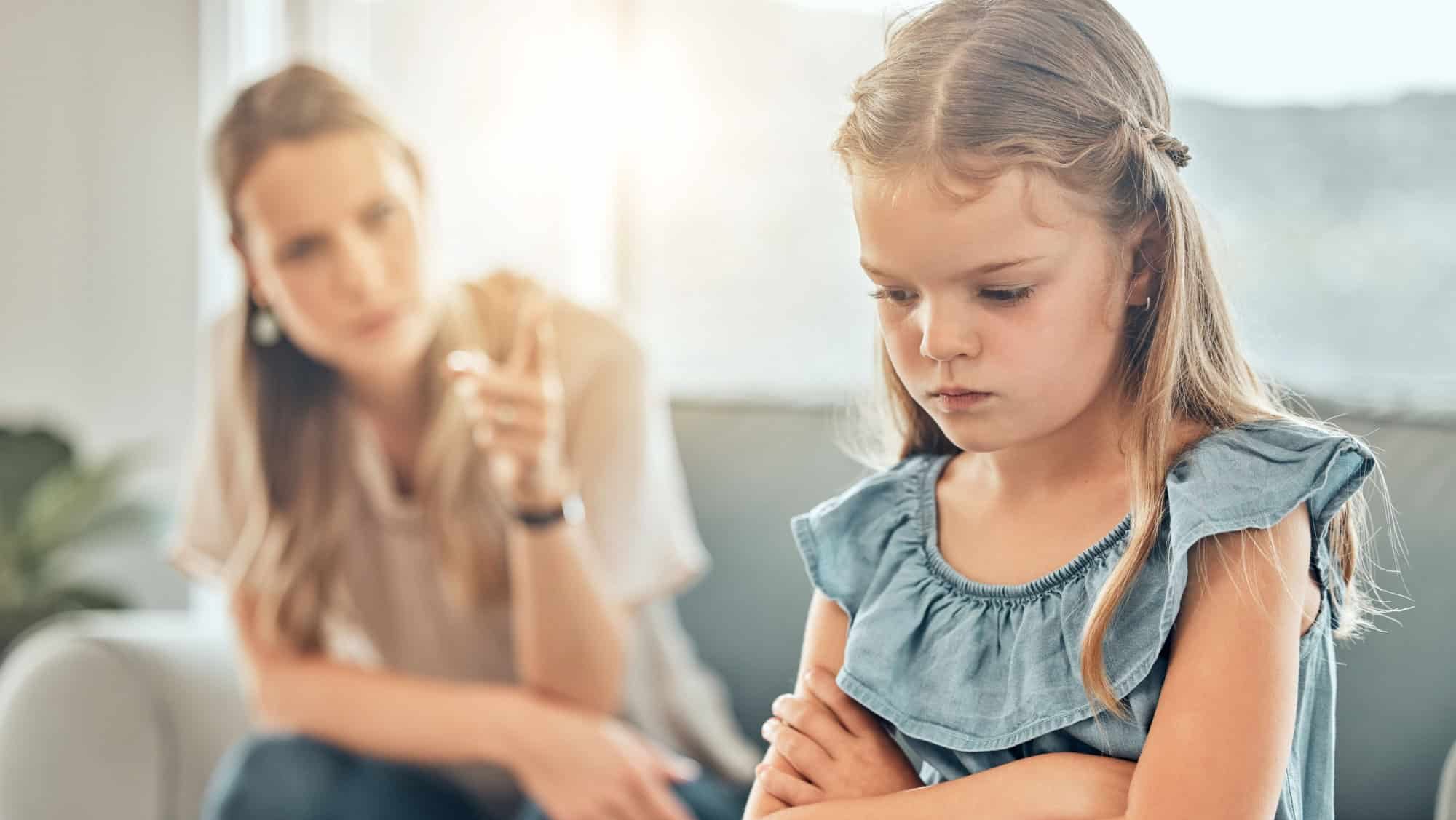 Angry lecture from mom, sad child and discipline in living room, problem with naughty girl behaviour in home. Scolding, punishment and frustrated mother, stubborn kid and communication with anger.