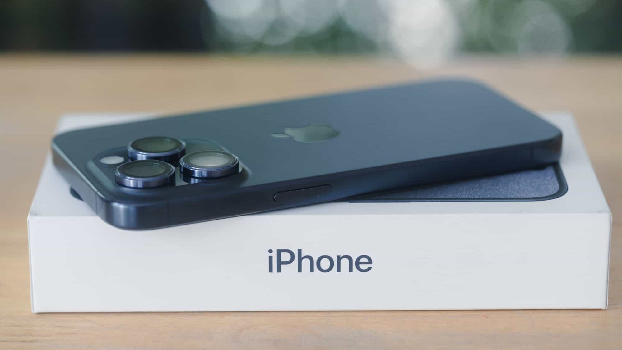 Bangkok, Thailand - October 27, 2023 : Back view of new iPhone 15 Pro Titanium Blue, lies face down in a box. A tech smartphone modern design