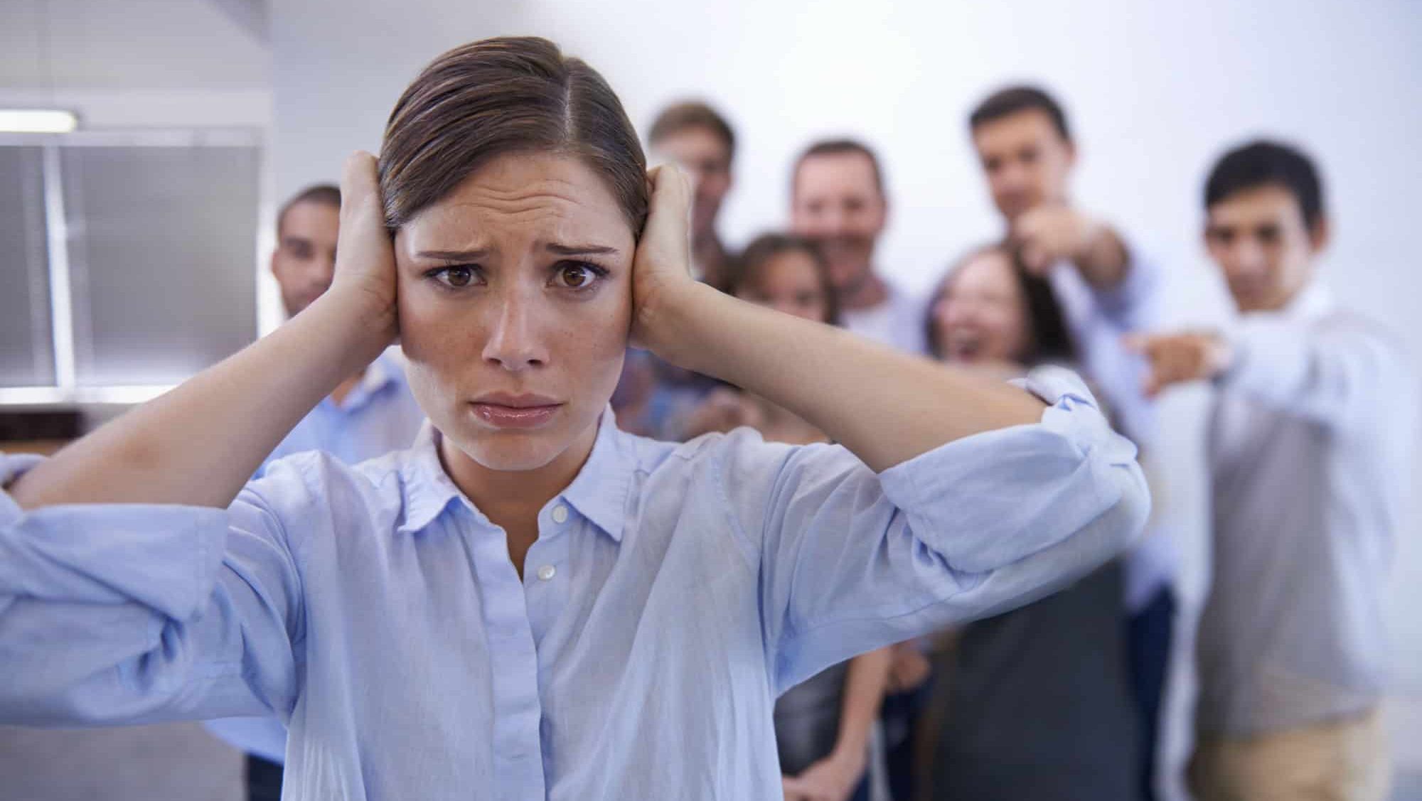 Business, bullying and portrait of woman with stress in office with harassment, prank or hand pointing mock. Judgment, joke and face of worker with new job judgment, shame or corporate gossip victim