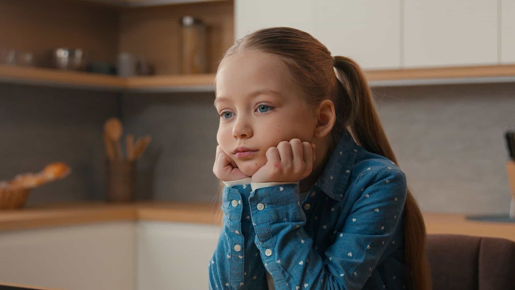 Portrait sorrow grief worried little offended Caucasian sad upset bored child girl schoolgirl orphan unhappy lonely kid at home kitchen alone depressed stressed daughter sadness family quarrel
