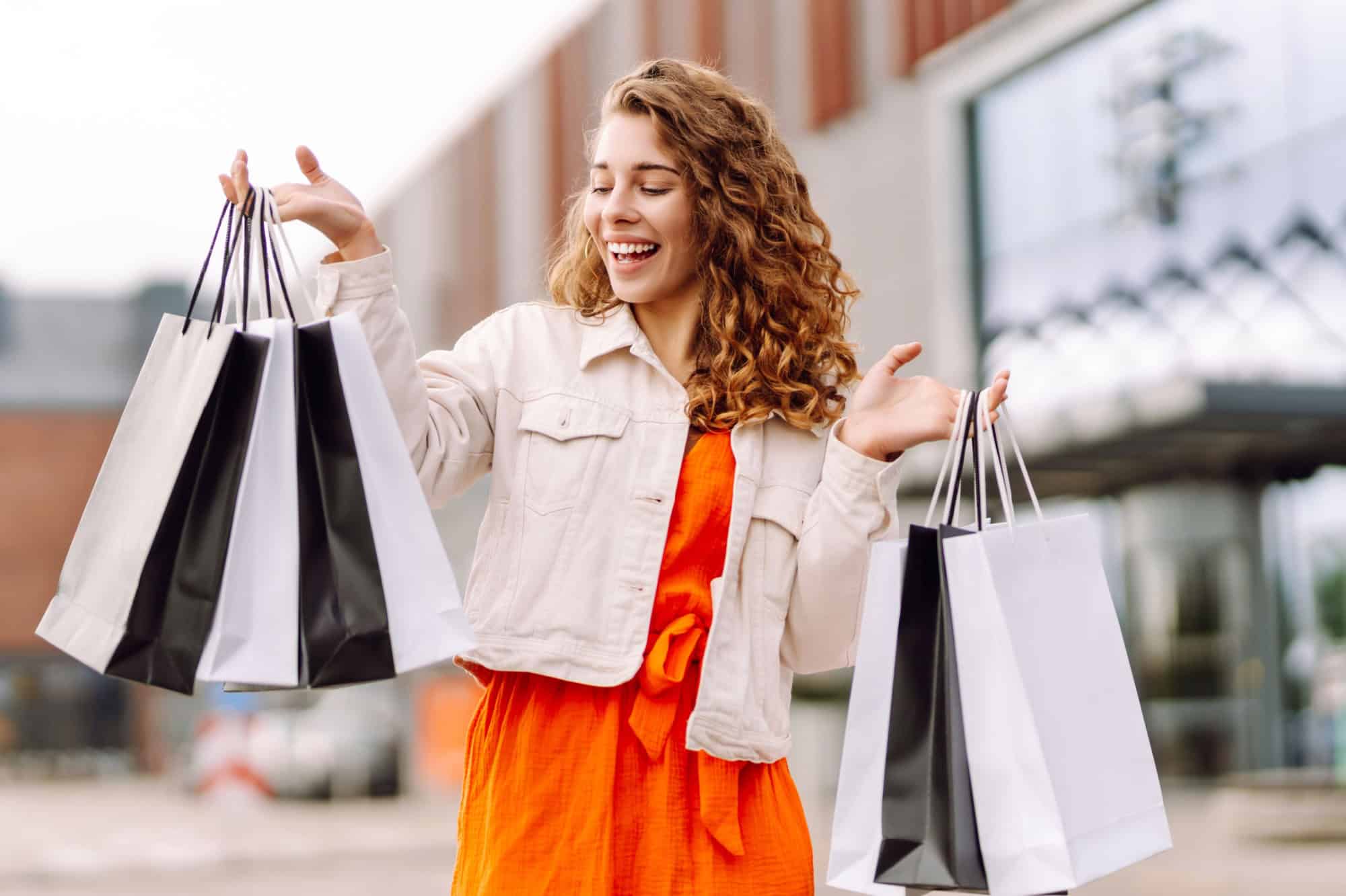 Fashion woman with shopping bags walking around the city after shopping. Consumerism, sale, purchases, shopping, lifestyle concept.