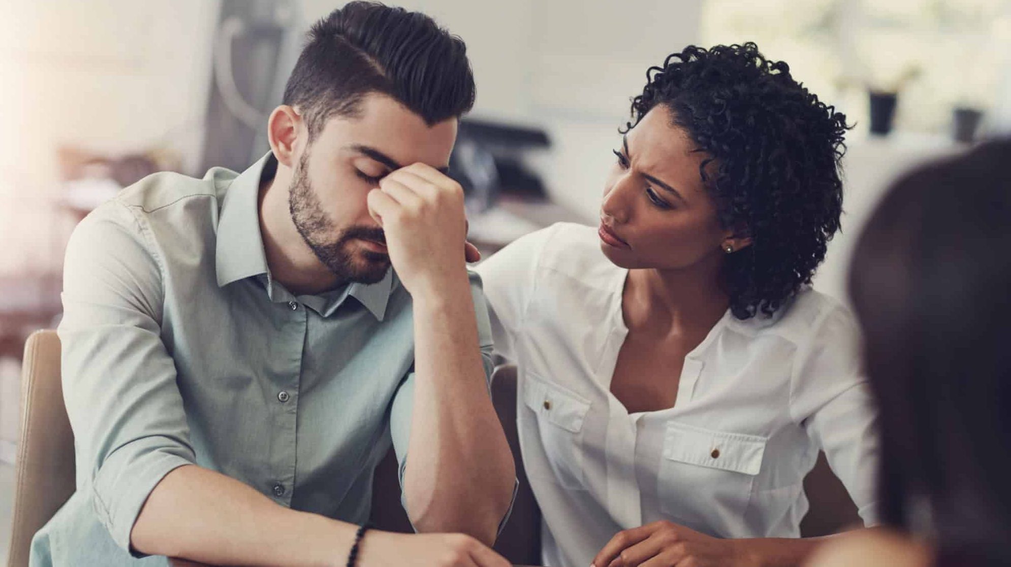 Couple, comfort and man with support in stress for counseling, compassion or advice on problem. Frustrated, person and woman with therapy by table for cheating mistake, regret or kindness in bad news