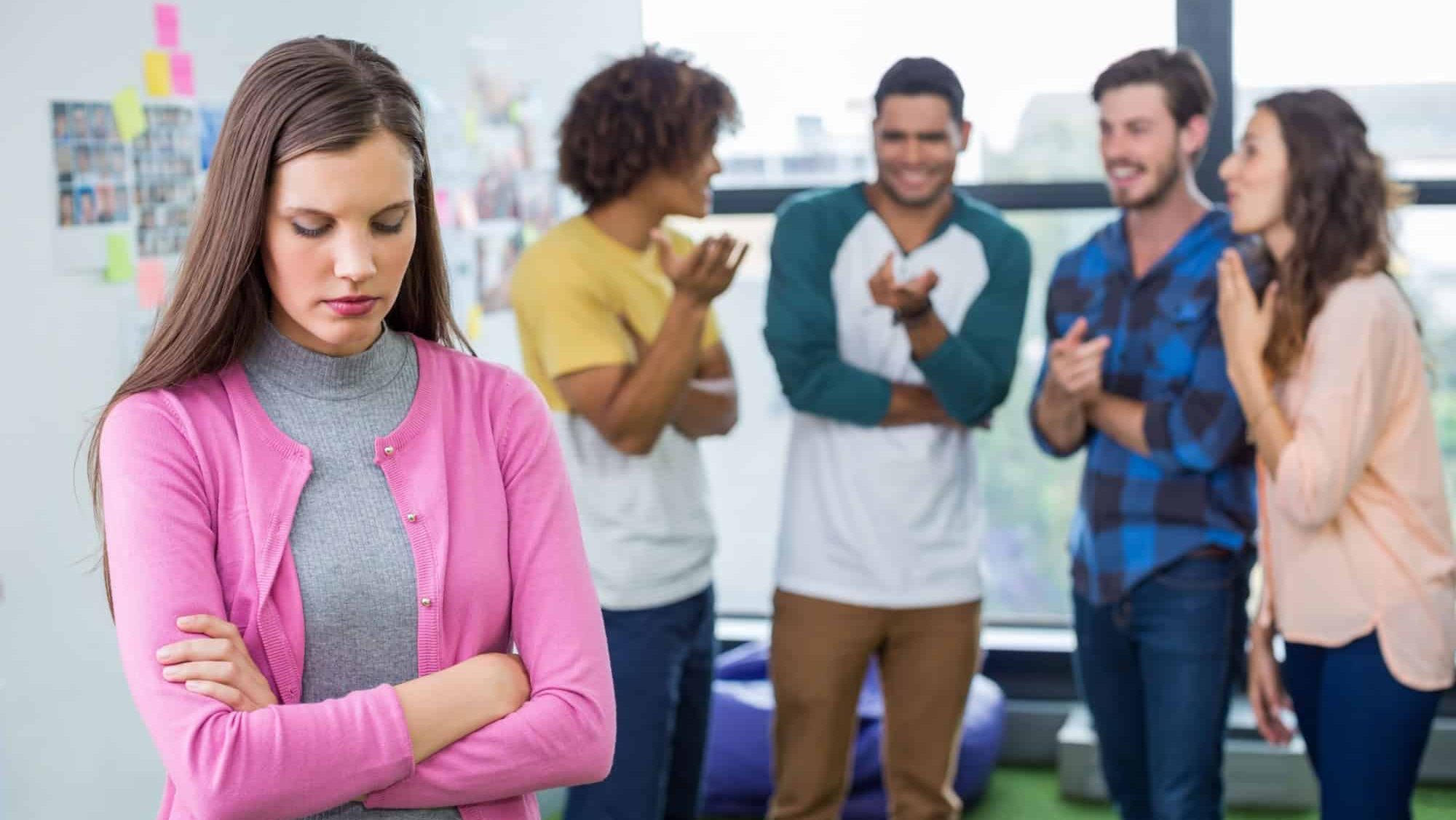 Colleagues bullying a sad female executive in office, teasing, failure, embarrassed