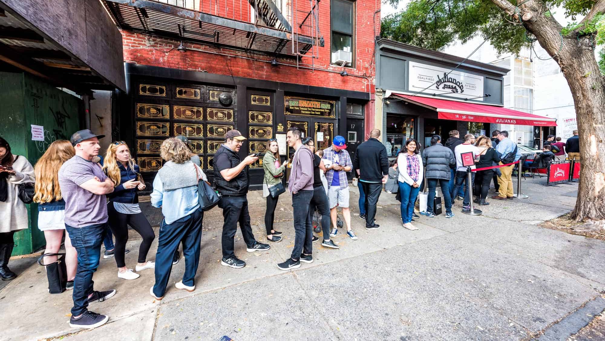 Brooklyn, USA - October 28, 2017: Long line queue of people crowd waiting for famous restaurant food called Juliana's Pizza