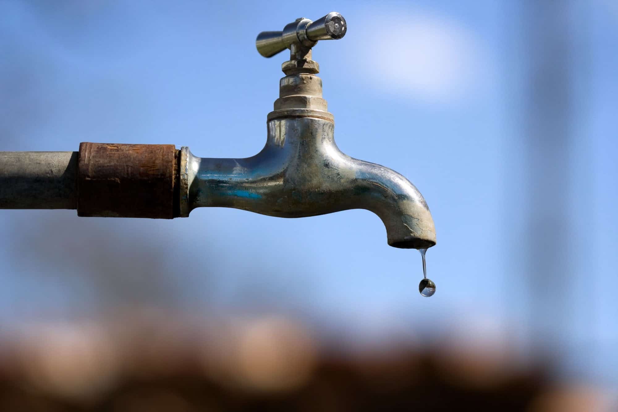 Water drop falling from an old tap