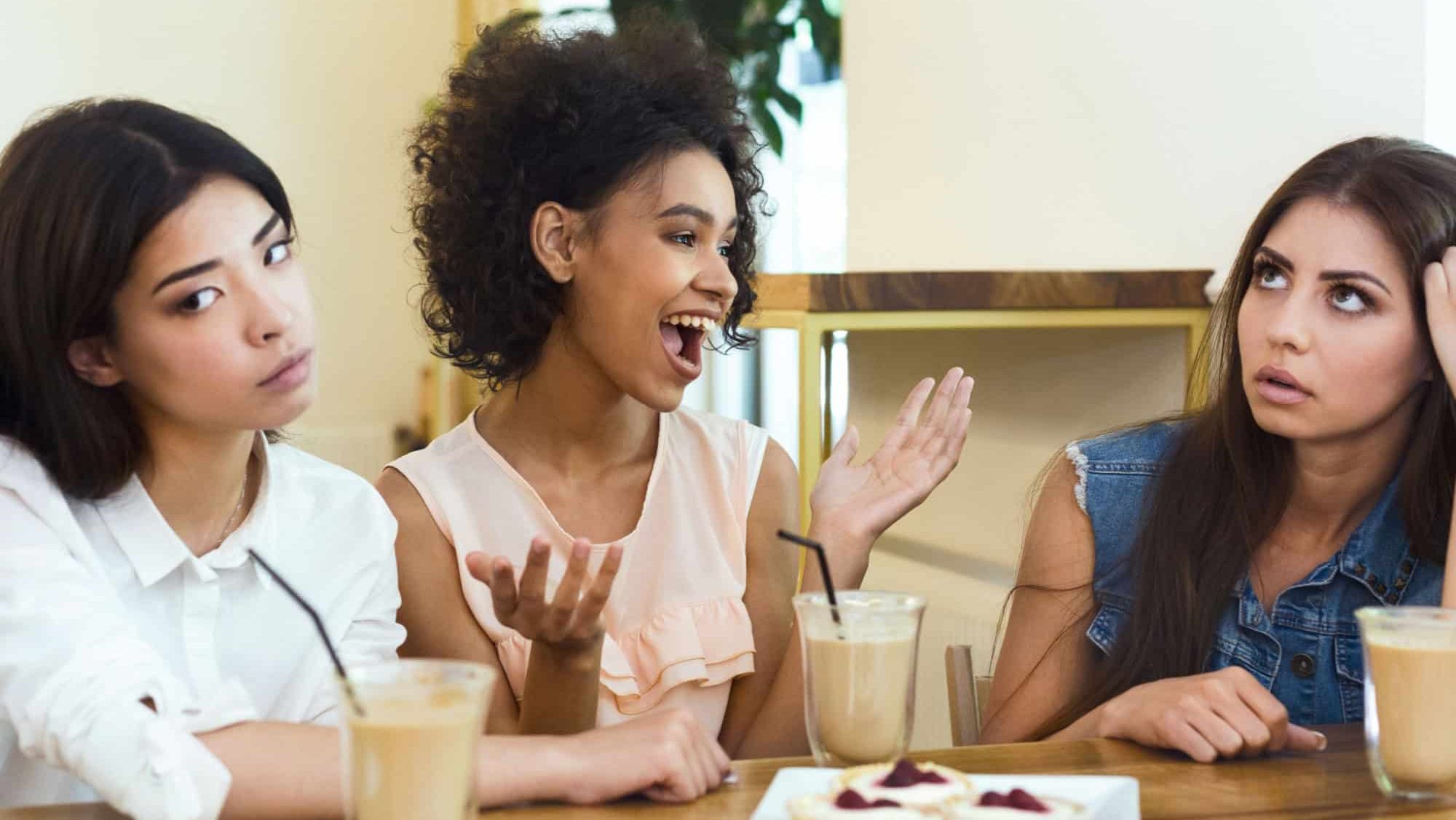 Annoying talkative friend sitting in cafe with girls and storytelling, her friends boring, panorama, empty space, concept