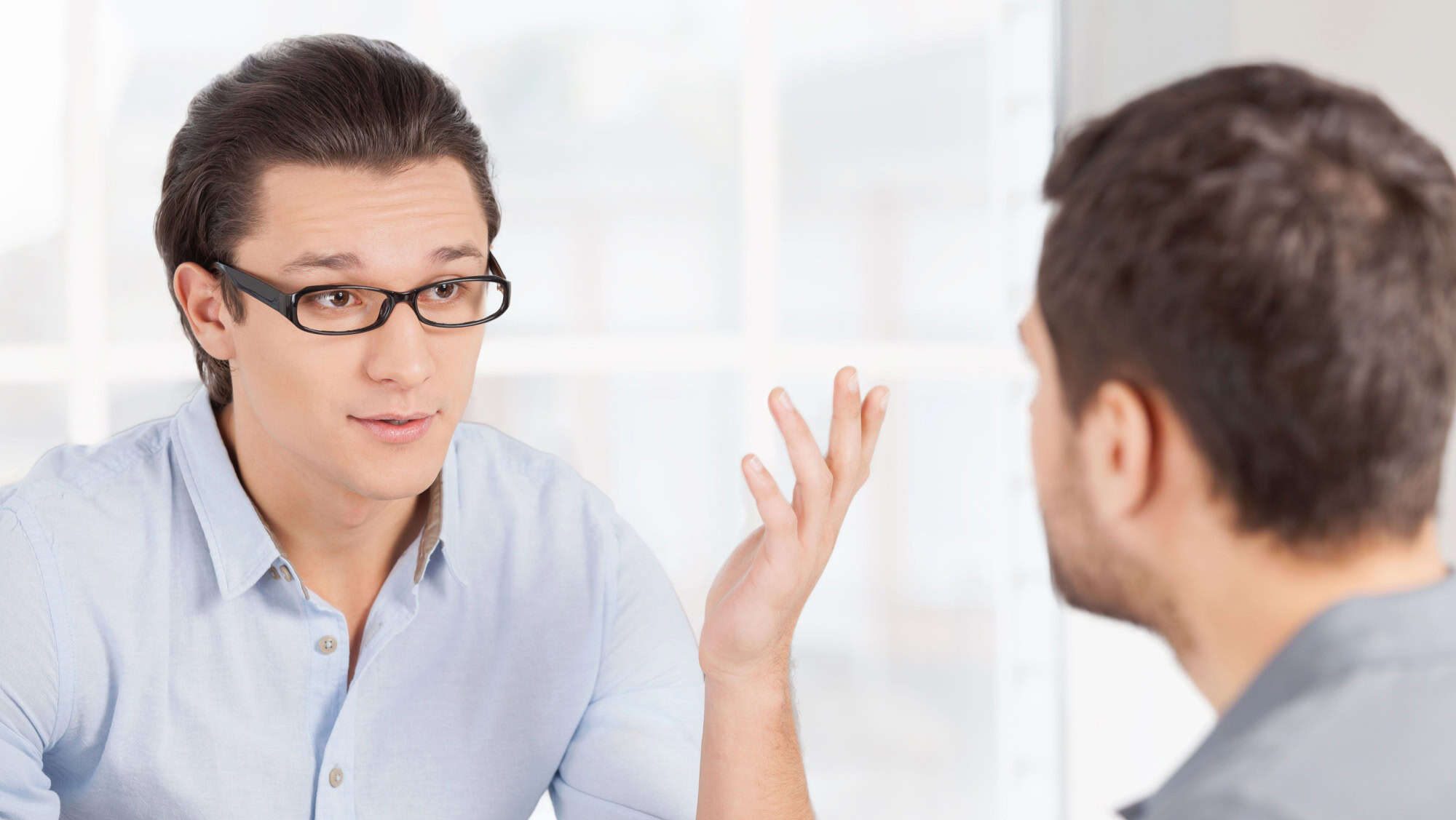 Business communication. Two confident business people in casual wear discussing something and gesturing