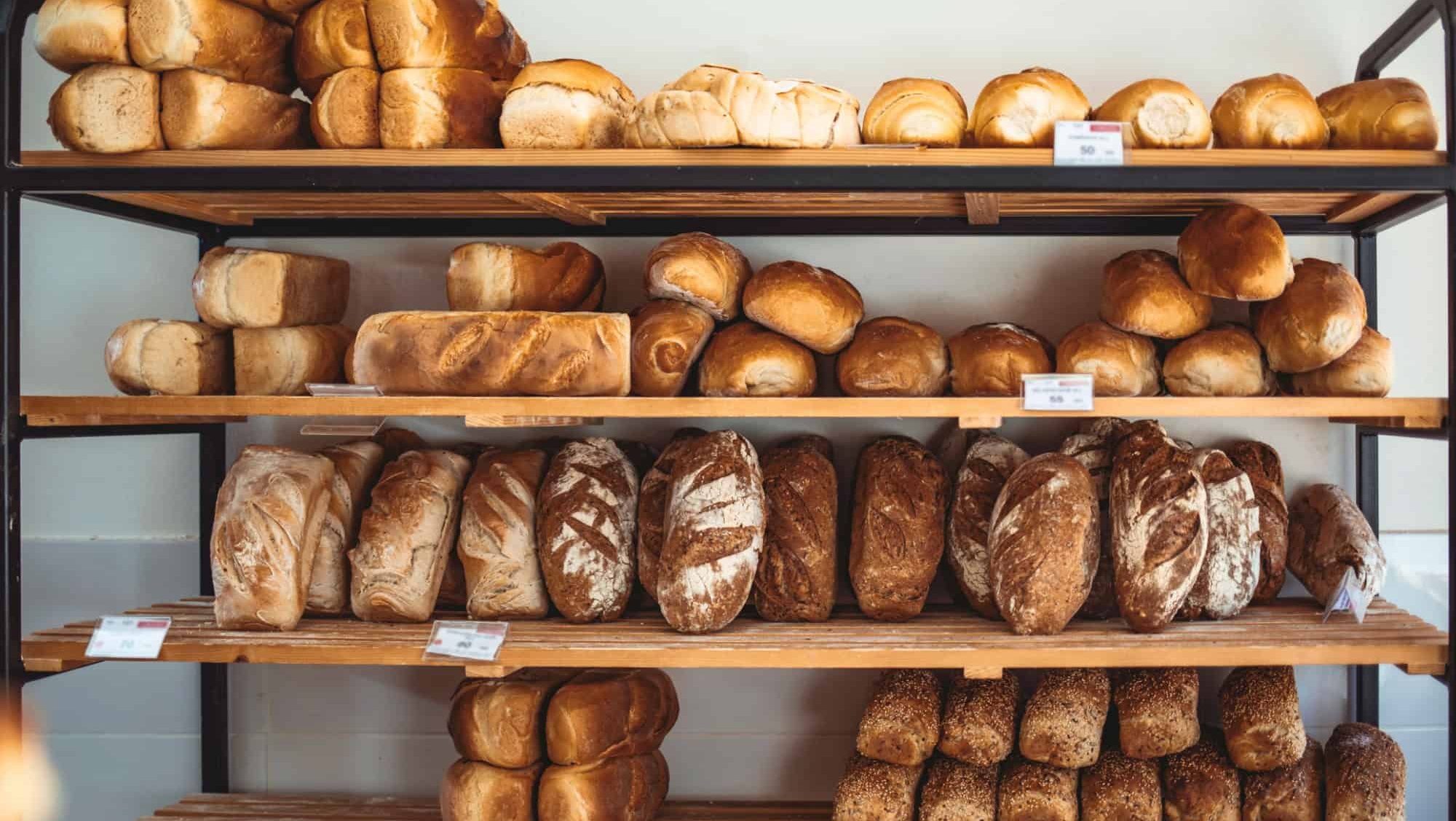 Fresh bread on shelves in bakery. Delicious loaves of bread in a german baker shop. Different types of bread loaves on bakery shelves. Modern bakery with assortment of bread