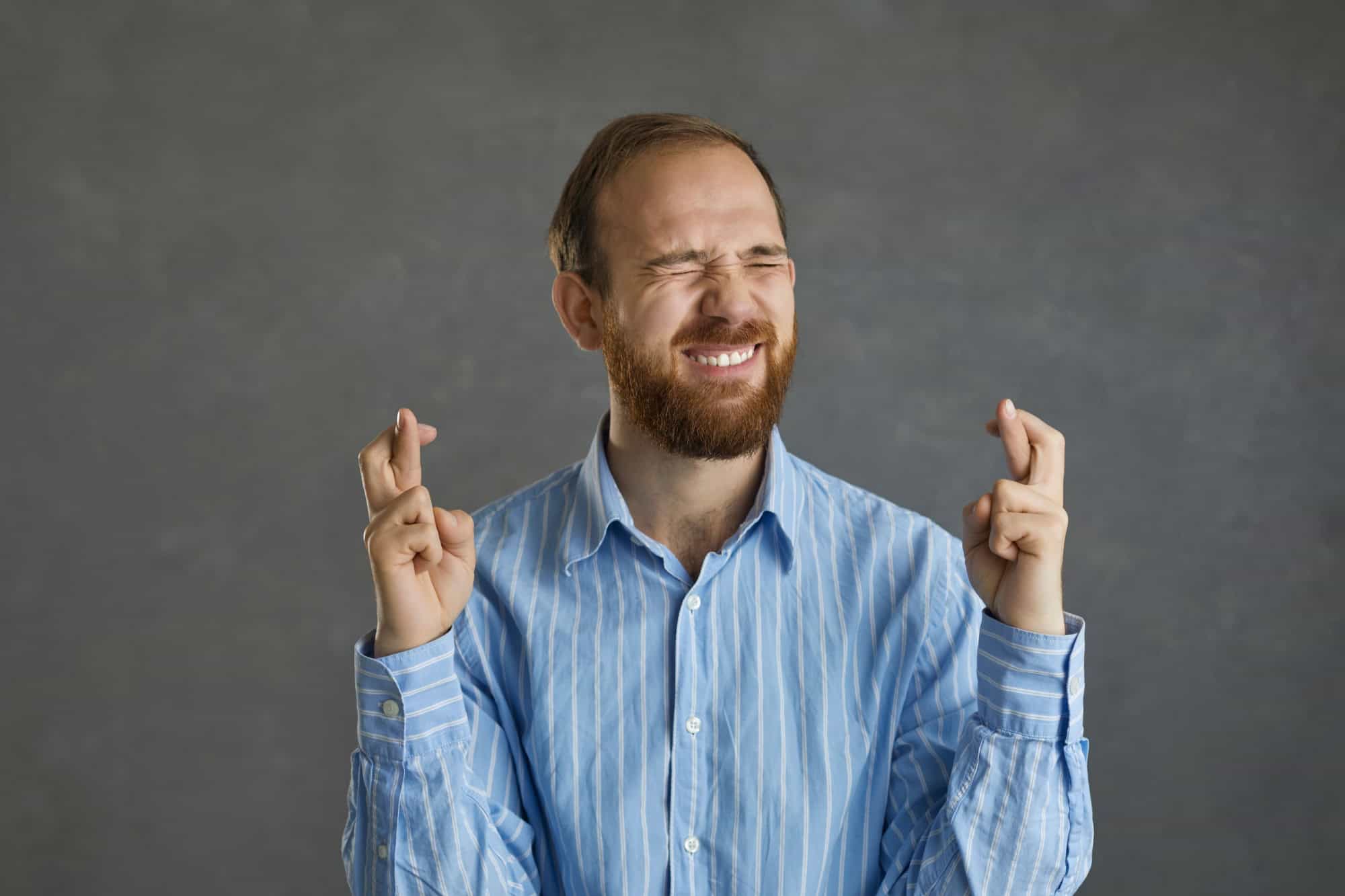 Please, let me get this job. Funny young business man or college student in office shirt asking god to make his wish come true, keeping fingers crossed, believing in luck and hoping for the best
