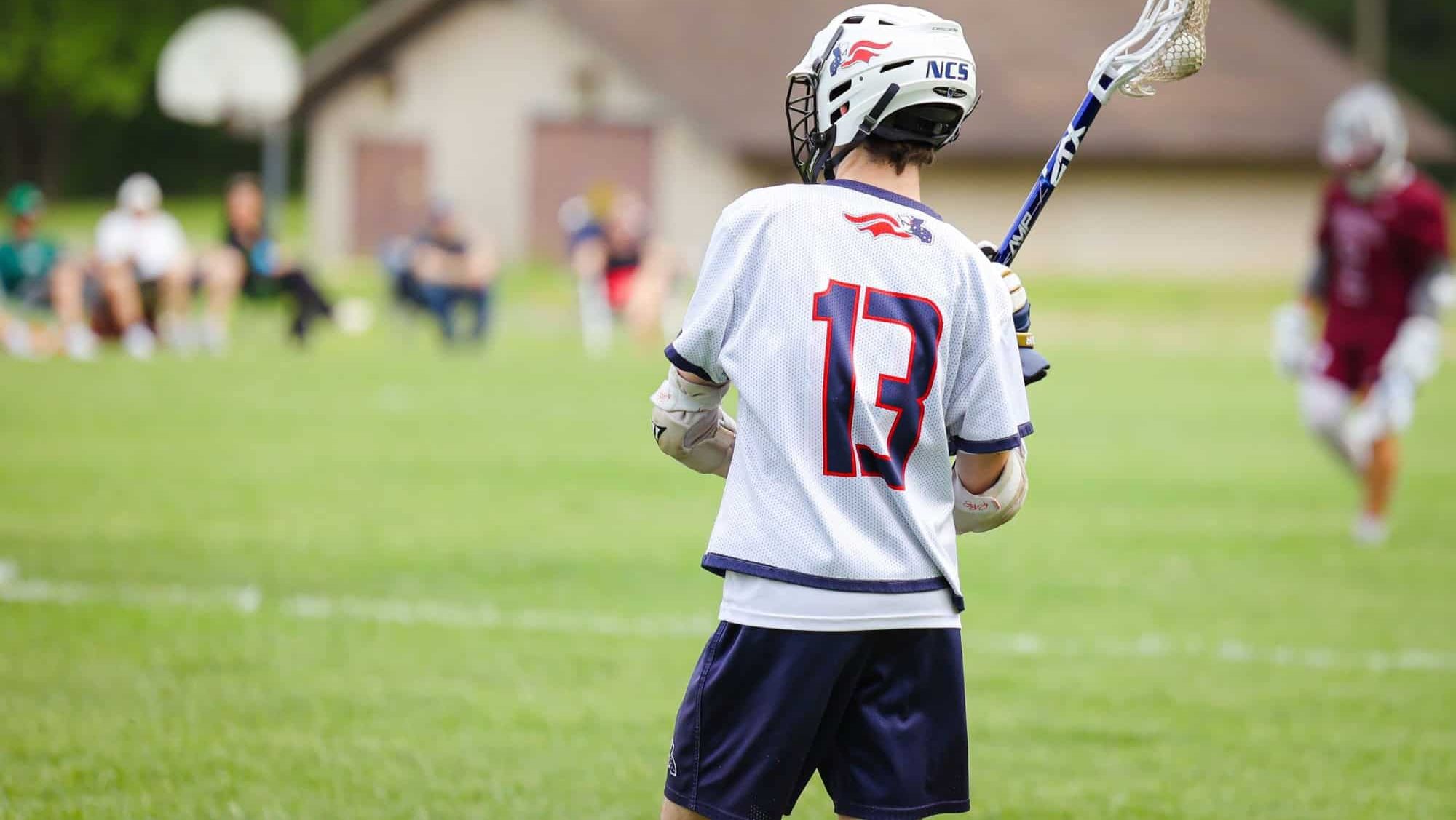 A lacrosse player in the green field in action