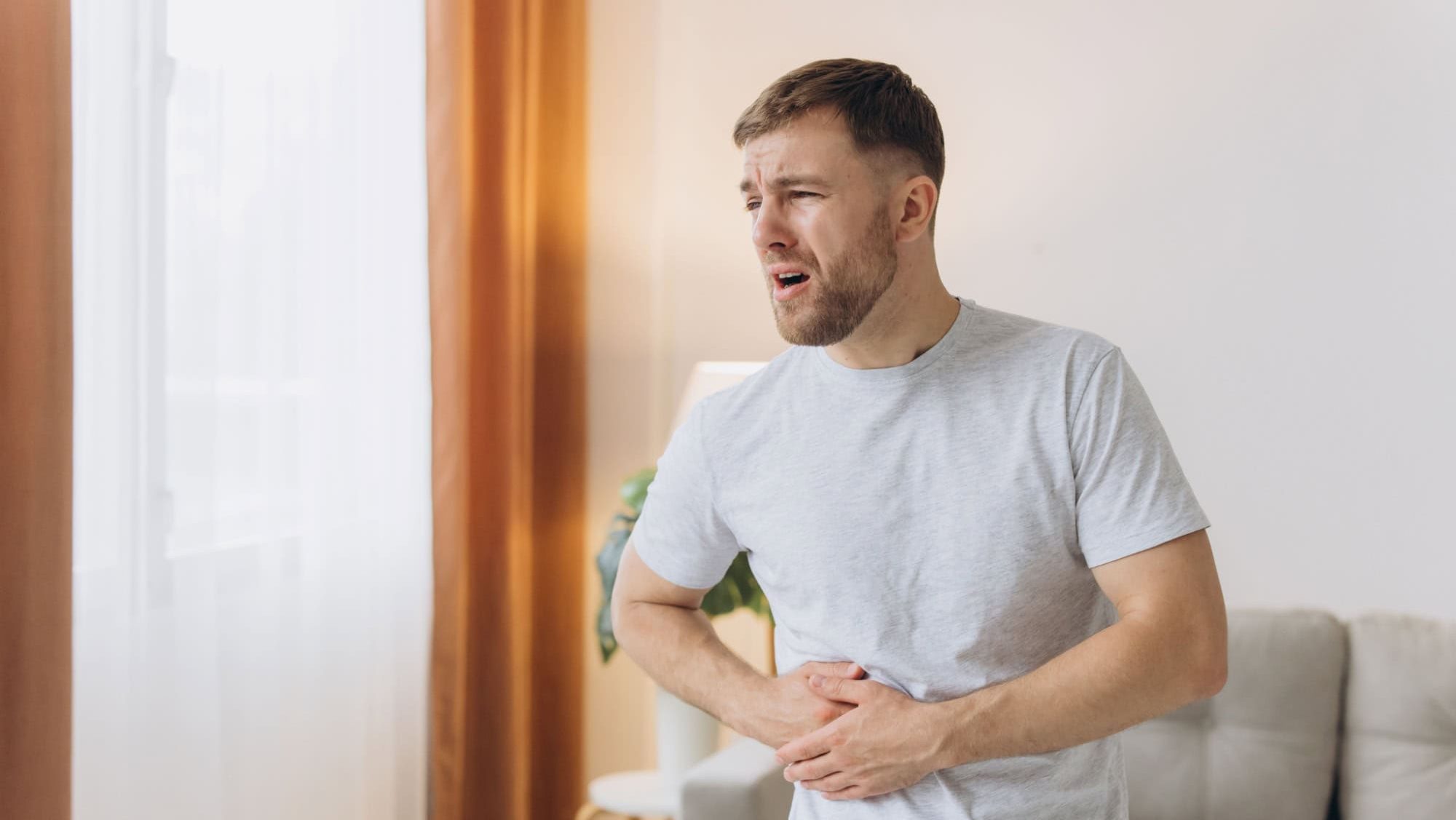 Young bearded guy freelance business man at home feels pain abdomen discomfort diarrhea liver problems appendicitis symptoms indigestion stomach spasm ache suffers from poisoning disease