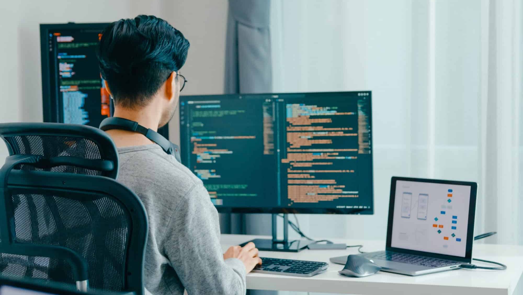 Young adult Asia male freelance eyeglasses typing write prompt AI bot IT app smart program nomad, video game, terminal with coding, user interface, designer, big data center on desktop computer.