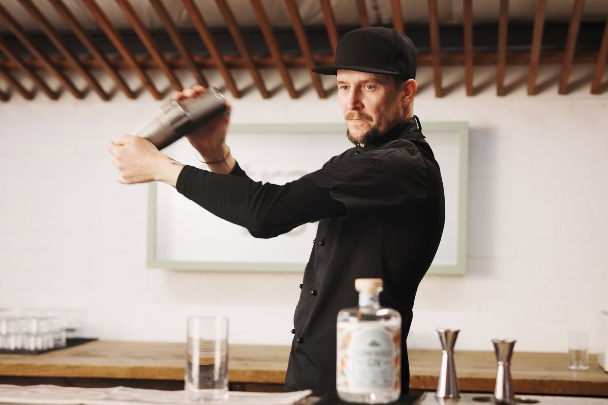Cocktail, cafe and bartender man with shaker, glass and tools for artisan beverage recipe. Mixology, small business pub and barman at gin bar counter with happy hour drinks, process and craft alcohol