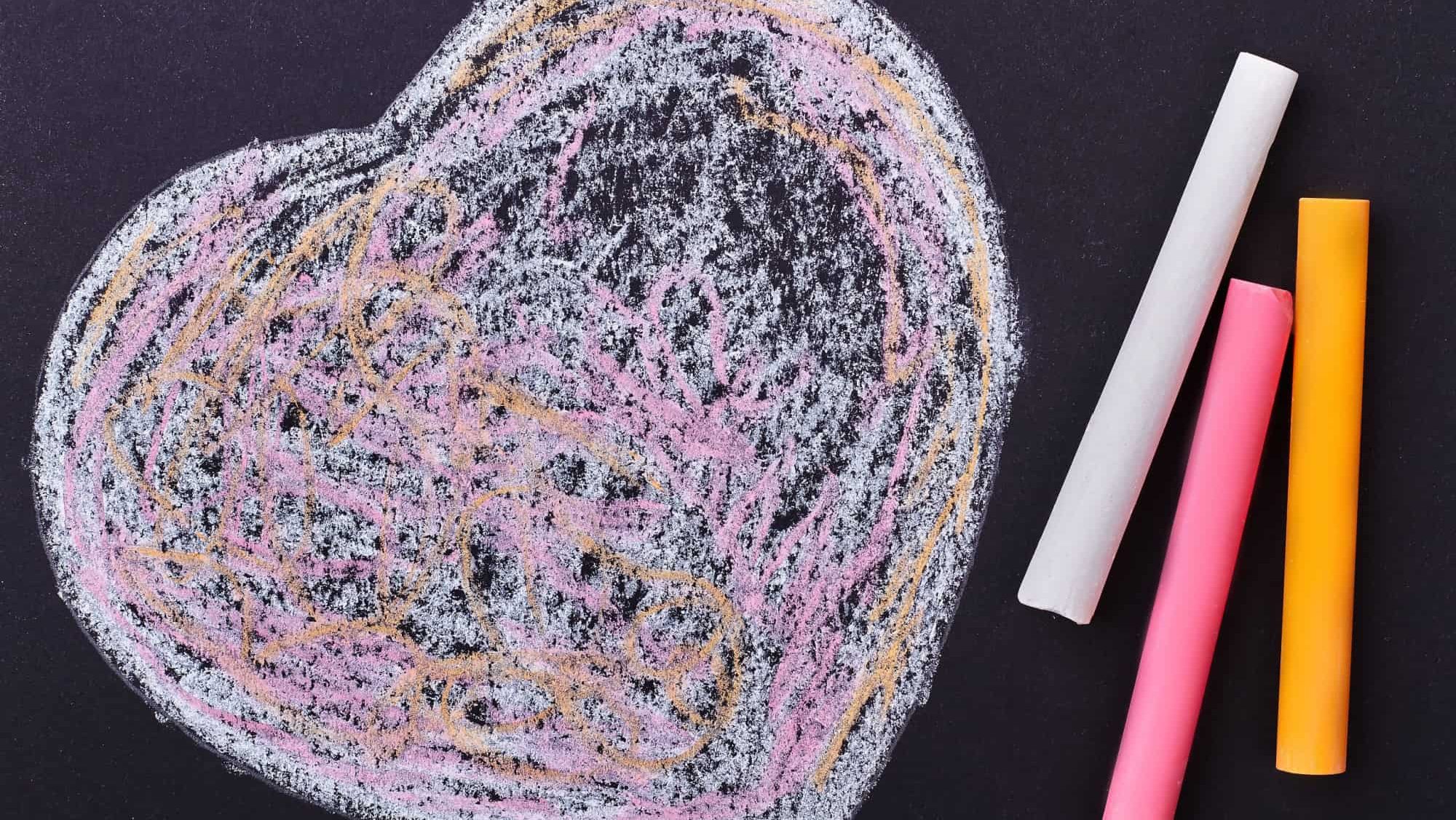 Doodle heart on black background. Colorful chalk sticks and heart. Simple but creative surprise.