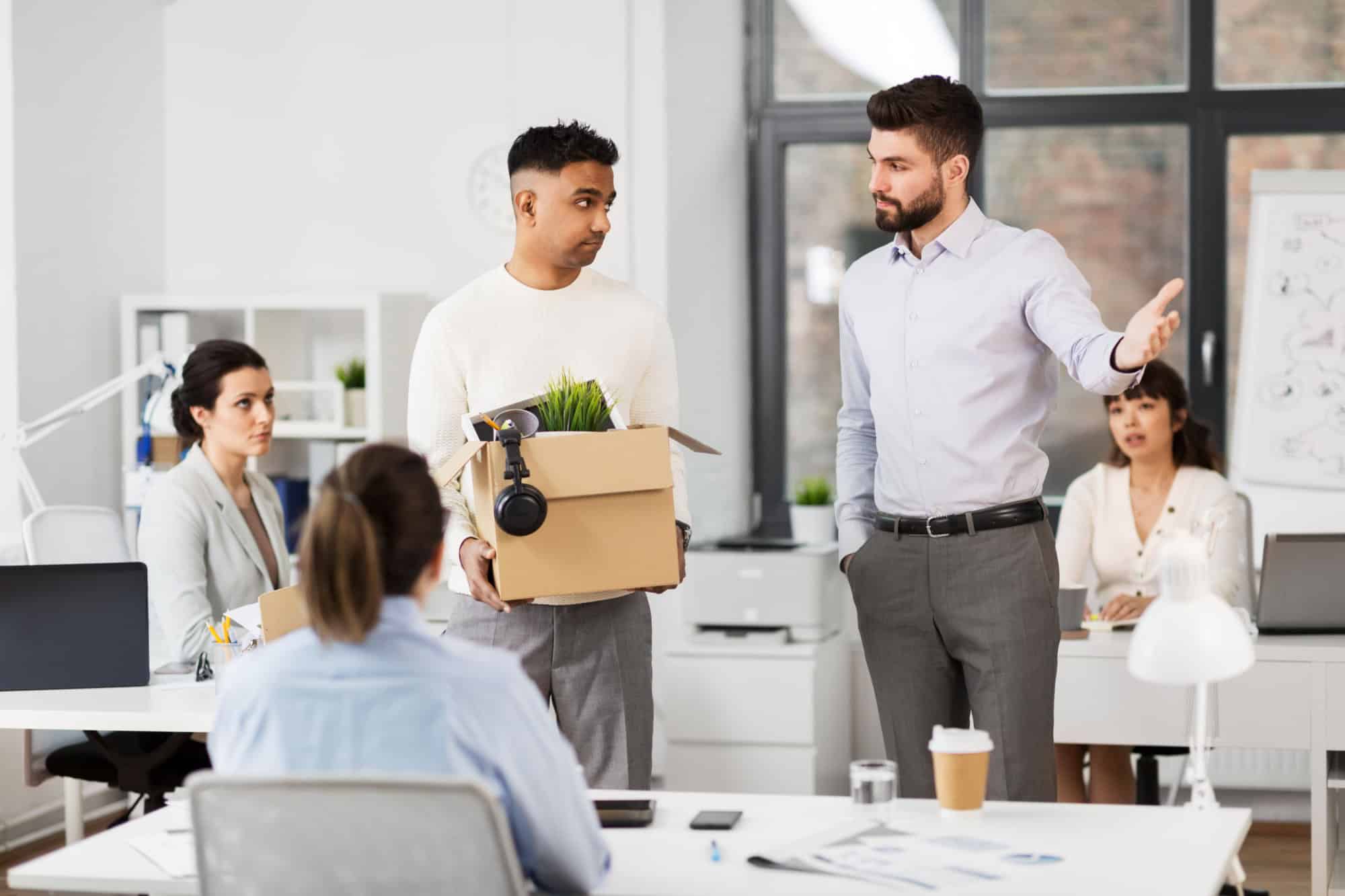business, firing and job loss concept - fired sad male office worker with box of personal stuff leaving